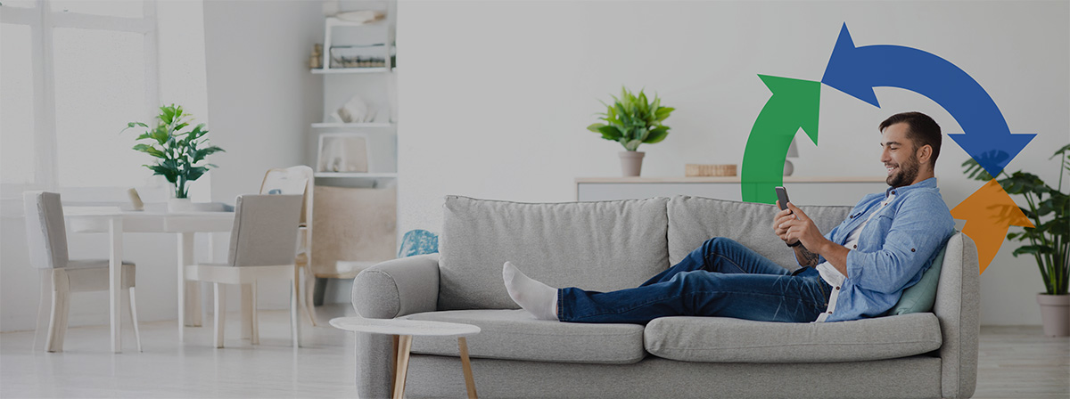 A man lays on his couch and uses his cellphone connected to the internet with a Conexon logo overtop.